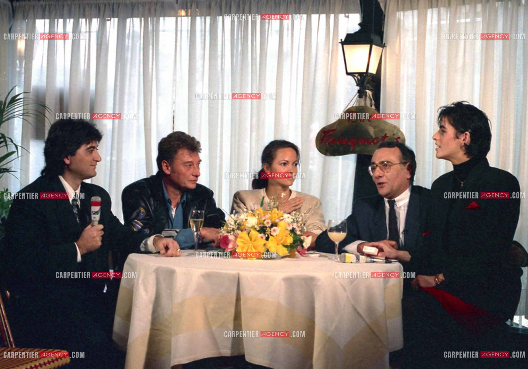 Johnny Hallyday lors du lancement de sa marque de blousons en compagnie de Gisèle Galante, Yves Mourousi et sa femme Véronique Audemard d'Alançon Mourousi à Paris le 4 février 1988.  ( Exclusif )