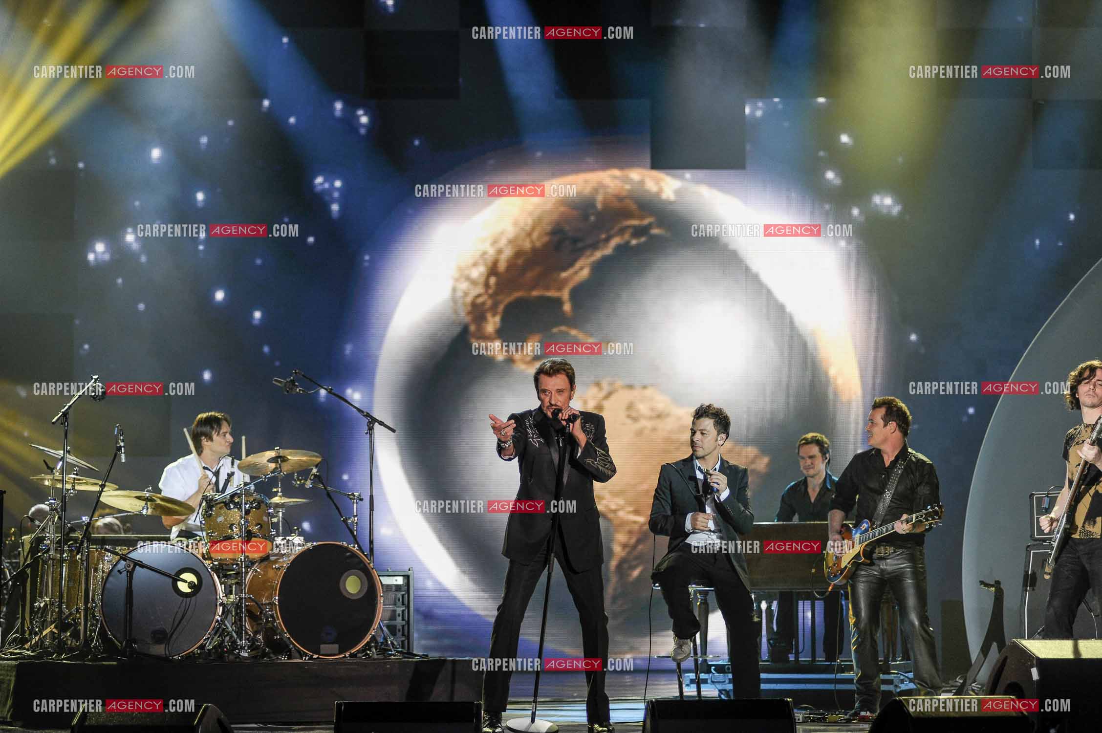 Johnny Hallyday interprète “Ça peut changer le monde“ accompagné de son fils David Hallyday à la batterie, Christophe Maé à l'armonica, et Axel Bauer à la guitare aux Victoires de la musique en 2009 au Zénith de Paris.