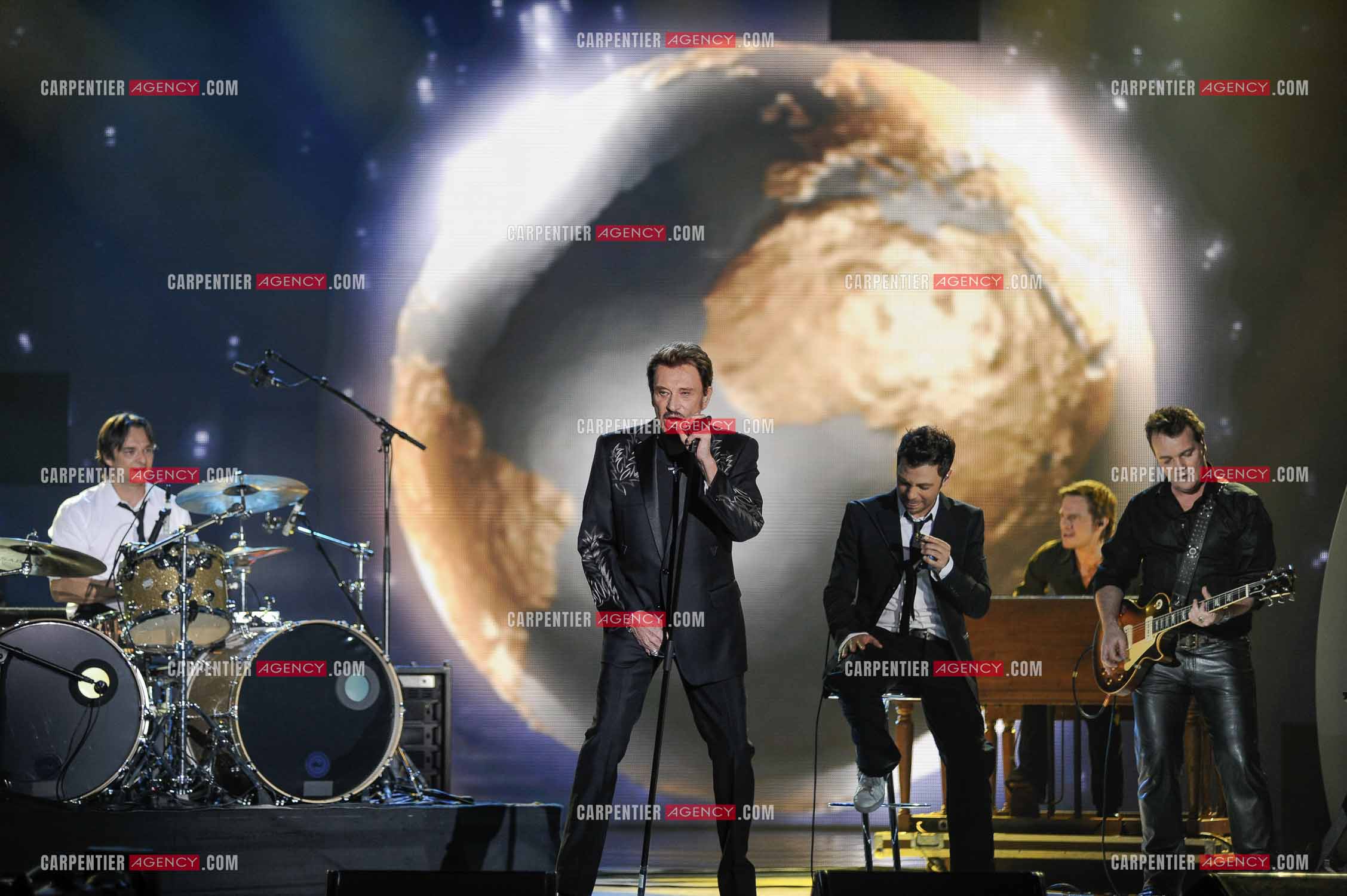 Johnny Hallyday interprète “Ça peut changer le monde“ accompagné de son fils David Hallyday à la batterie, Christophe Maé à l'armonica, et Axel Bauer à la guitare aux Victoires de la musique en 2009 au Zénith de Paris.