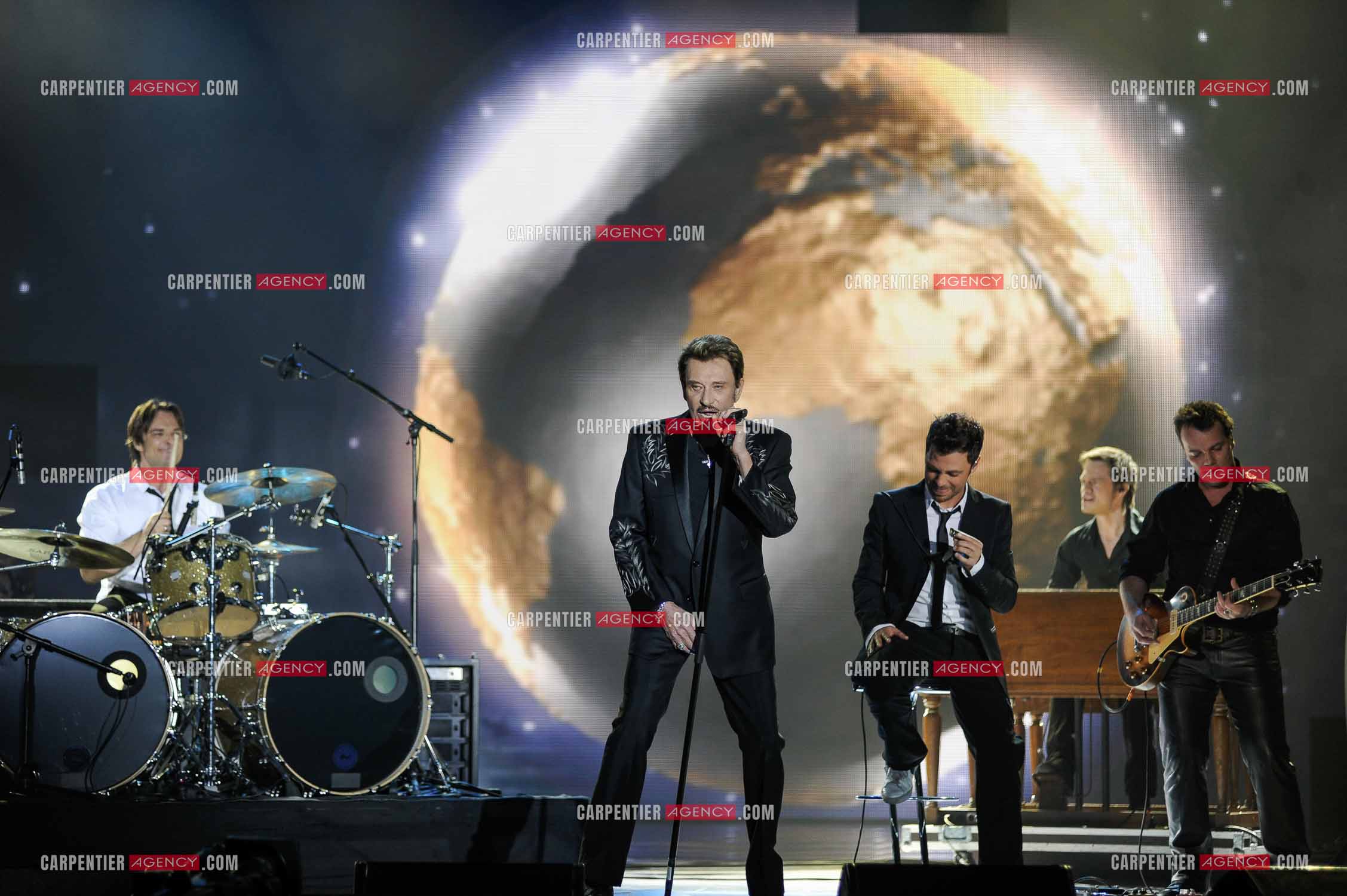 Johnny Hallyday interprète “Ça peut changer le monde“ accompagné de son fils David Hallyday à la batterie, Christophe Maé à l'armonica, et Axel Bauer à la guitare aux Victoires de la musique en 2009 au Zénith de Paris.