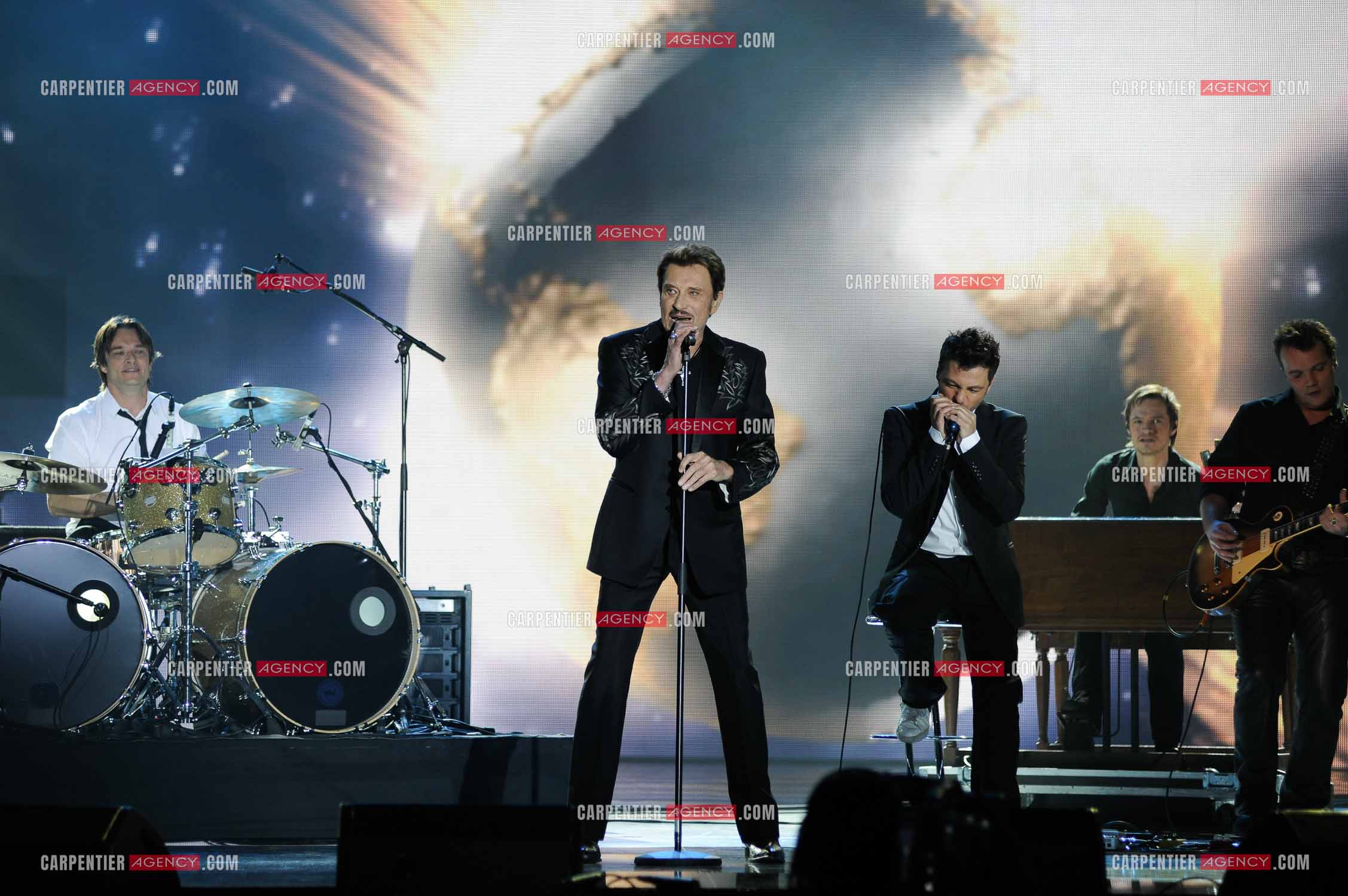Johnny Hallyday interprète “Ça peut changer le monde“ accompagné de son fils David Hallyday à la batterie, Christophe Maé à l'armonica, et Axel Bauer à la guitare aux Victoires de la musique en 2009 au Zénith de Paris.