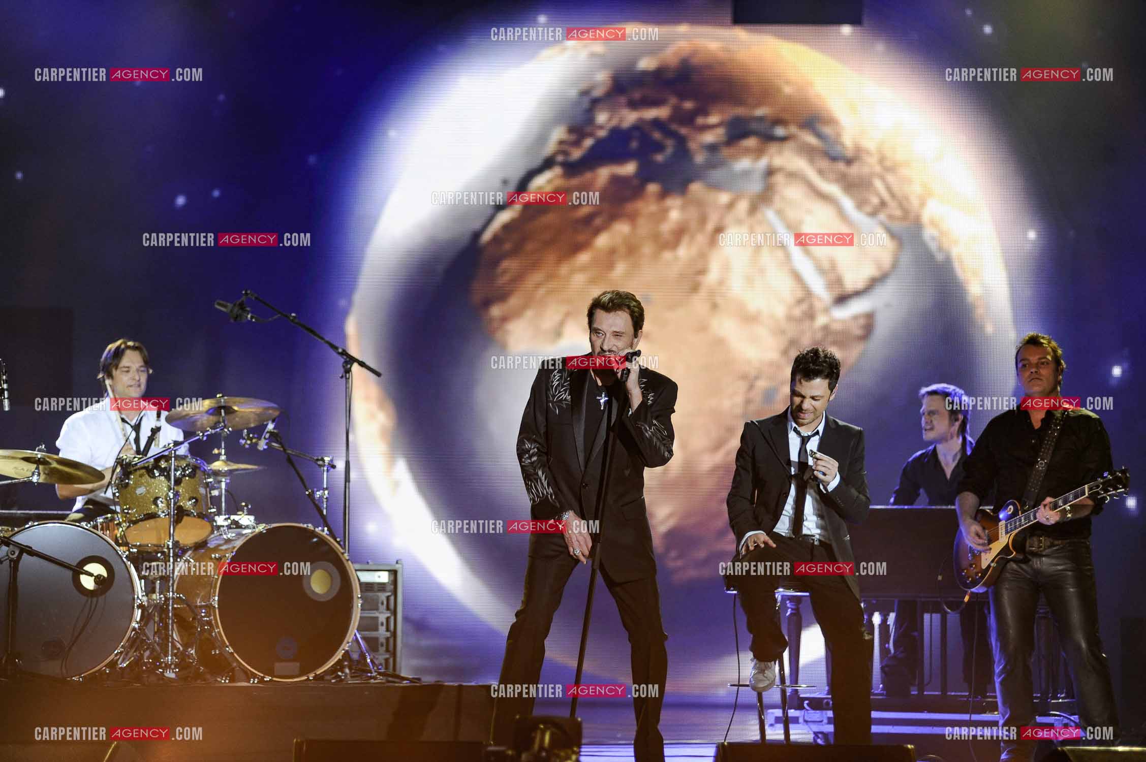 Johnny Hallyday interprète “Ça peut changer le monde“ accompagné de son fils David Hallyday à la batterie, Christophe Maé à l'armonica, et Axel Bauer à la guitare aux Victoires de la musique en 2009 au Zénith de Paris.