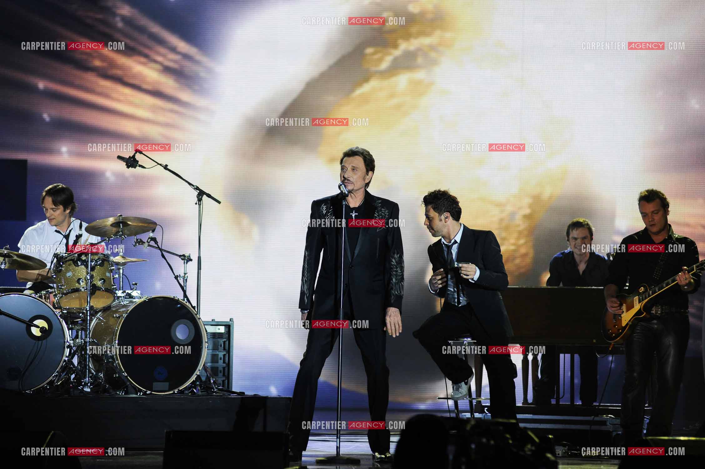 Johnny Hallyday interprète “Ça peut changer le monde“ accompagné de son fils David Hallyday à la batterie, Christophe Maé à l'armonica, et Axel Bauer à la guitare aux Victoires de la musique en 2009 au Zénith de Paris.