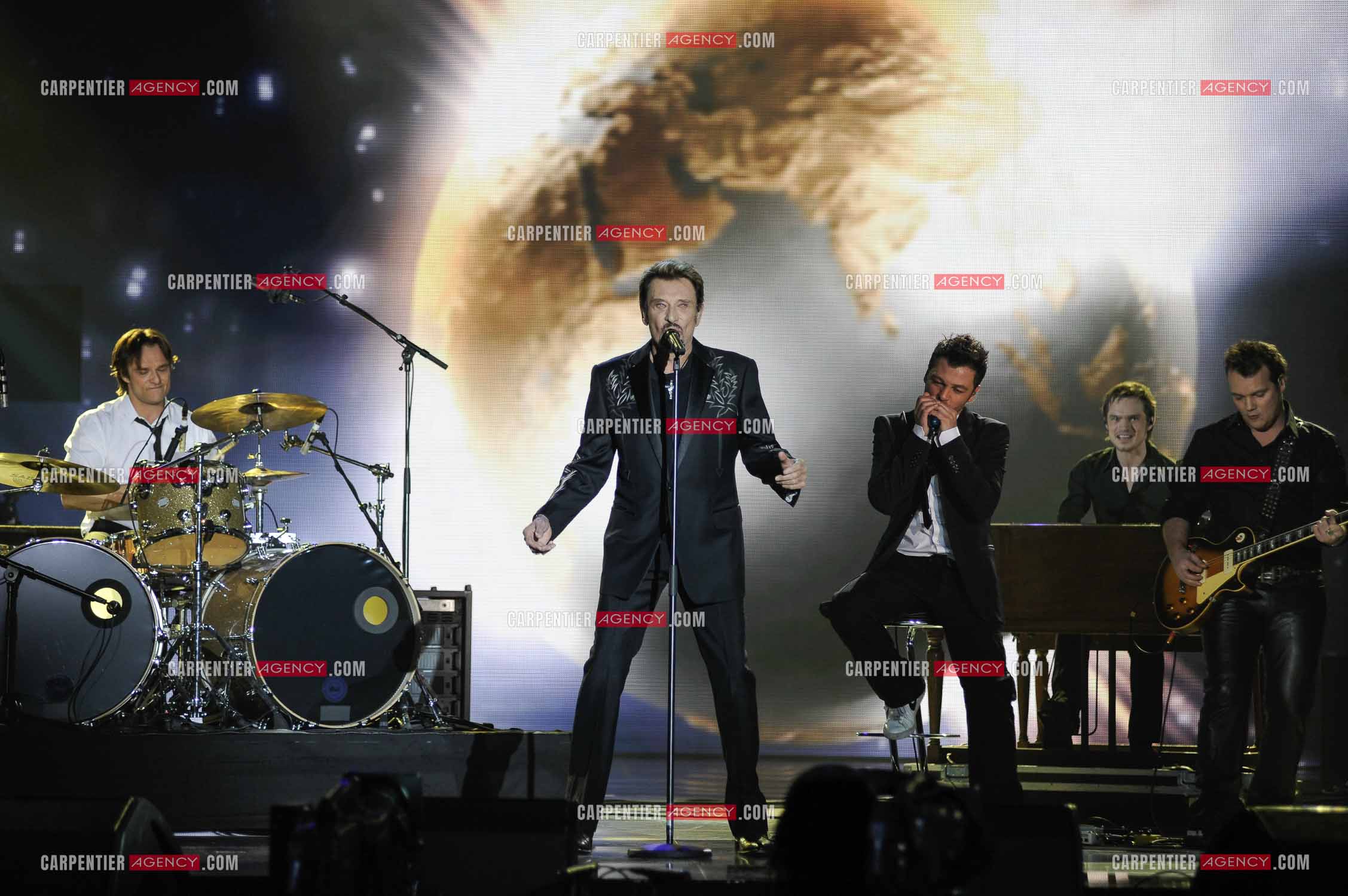 Johnny Hallyday interprète “Ça peut changer le monde“ accompagné de son fils David Hallyday à la batterie, Christophe Maé à l'armonica, et Axel Bauer à la guitare aux Victoires de la musique en 2009 au Zénith de Paris.