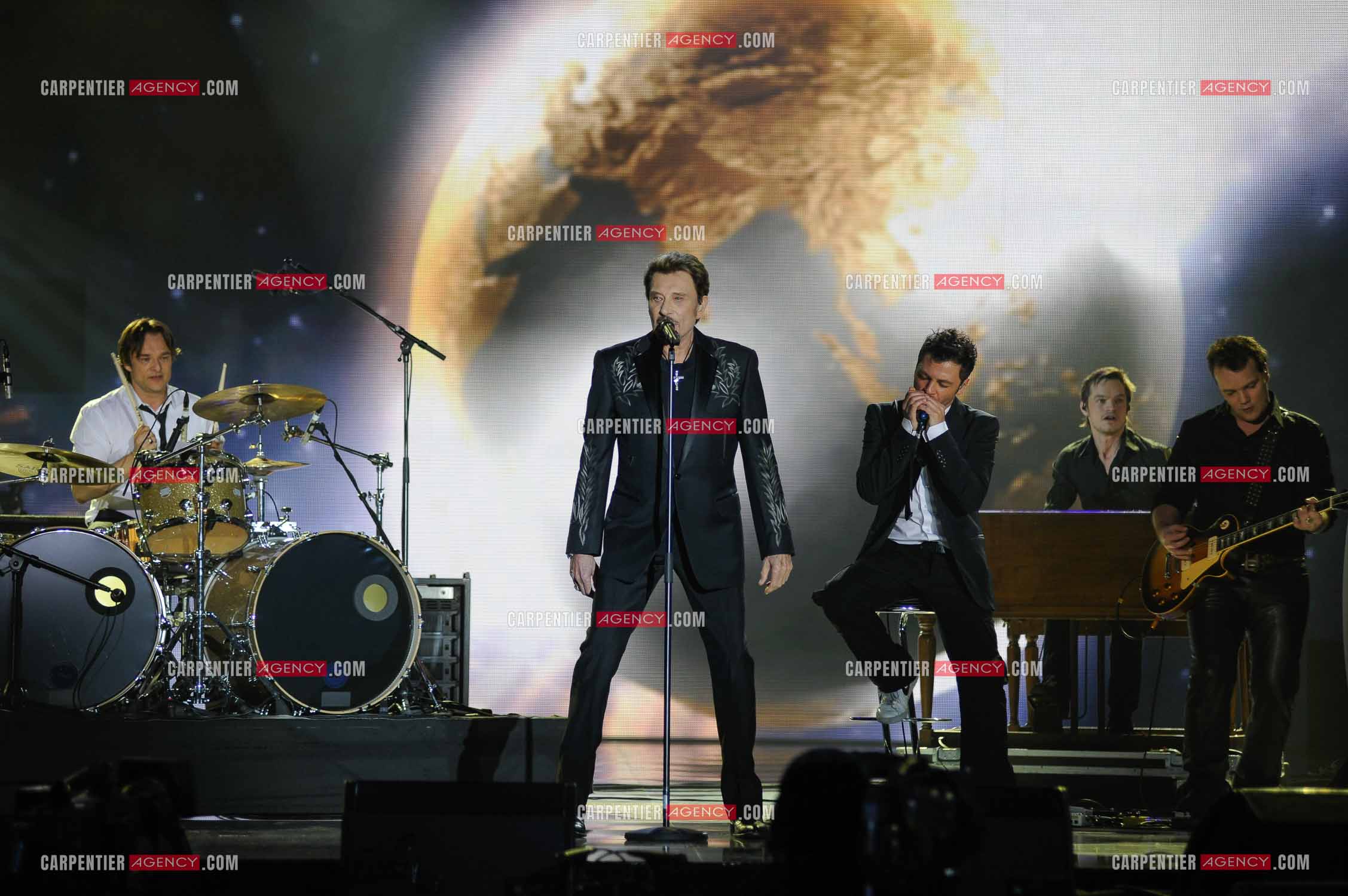 Johnny Hallyday interprète “Ça peut changer le monde“ accompagné de son fils David Hallyday à la batterie, Christophe Maé à l'armonica, et Axel Bauer à la guitare aux Victoires de la musique en 2009 au Zénith de Paris.