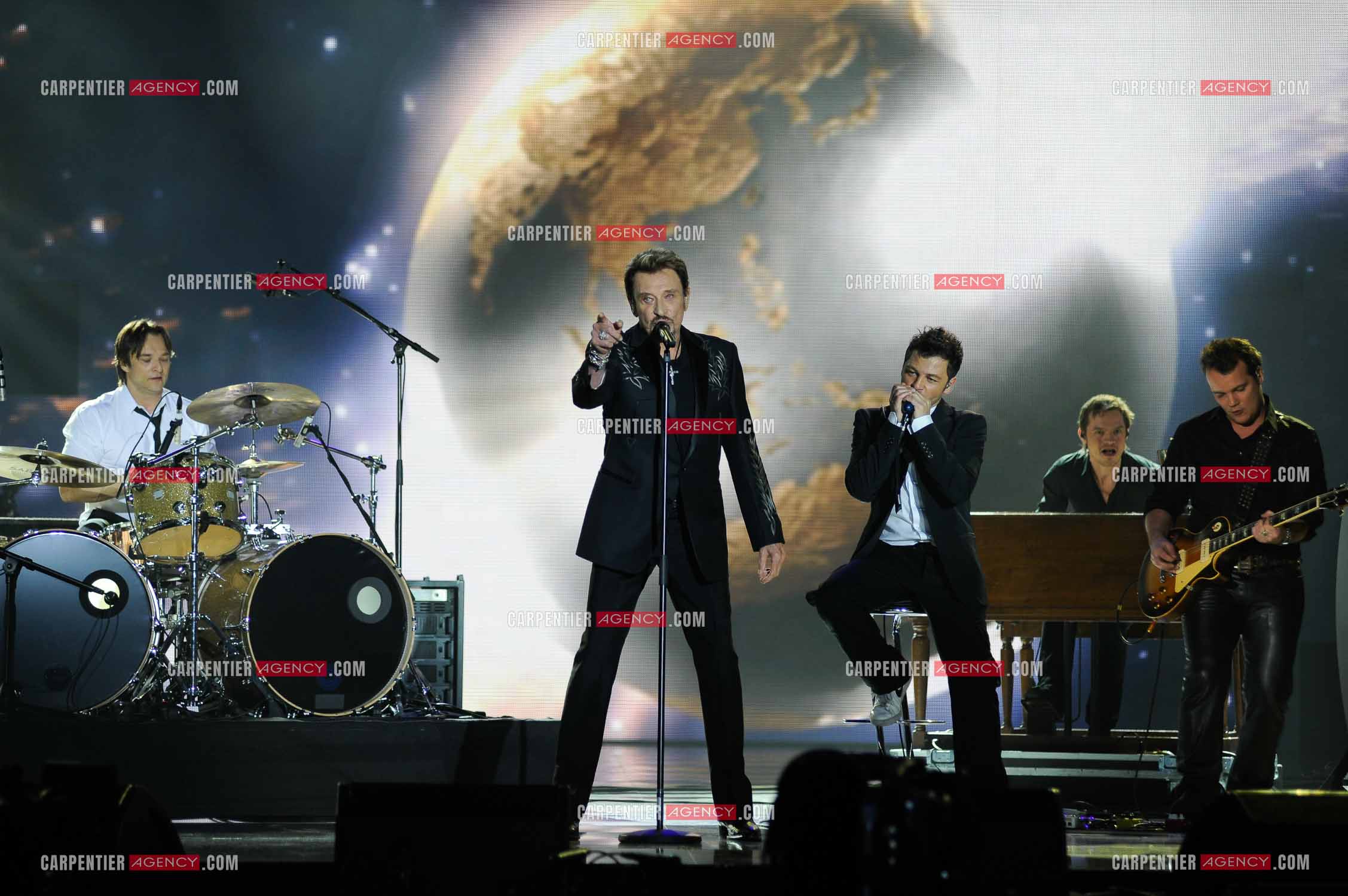 Johnny Hallyday interprète “Ça peut changer le monde“ accompagné de son fils David Hallyday à la batterie, Christophe Maé à l'armonica, et Axel Bauer à la guitare aux Victoires de la musique en 2009 au Zénith de Paris.