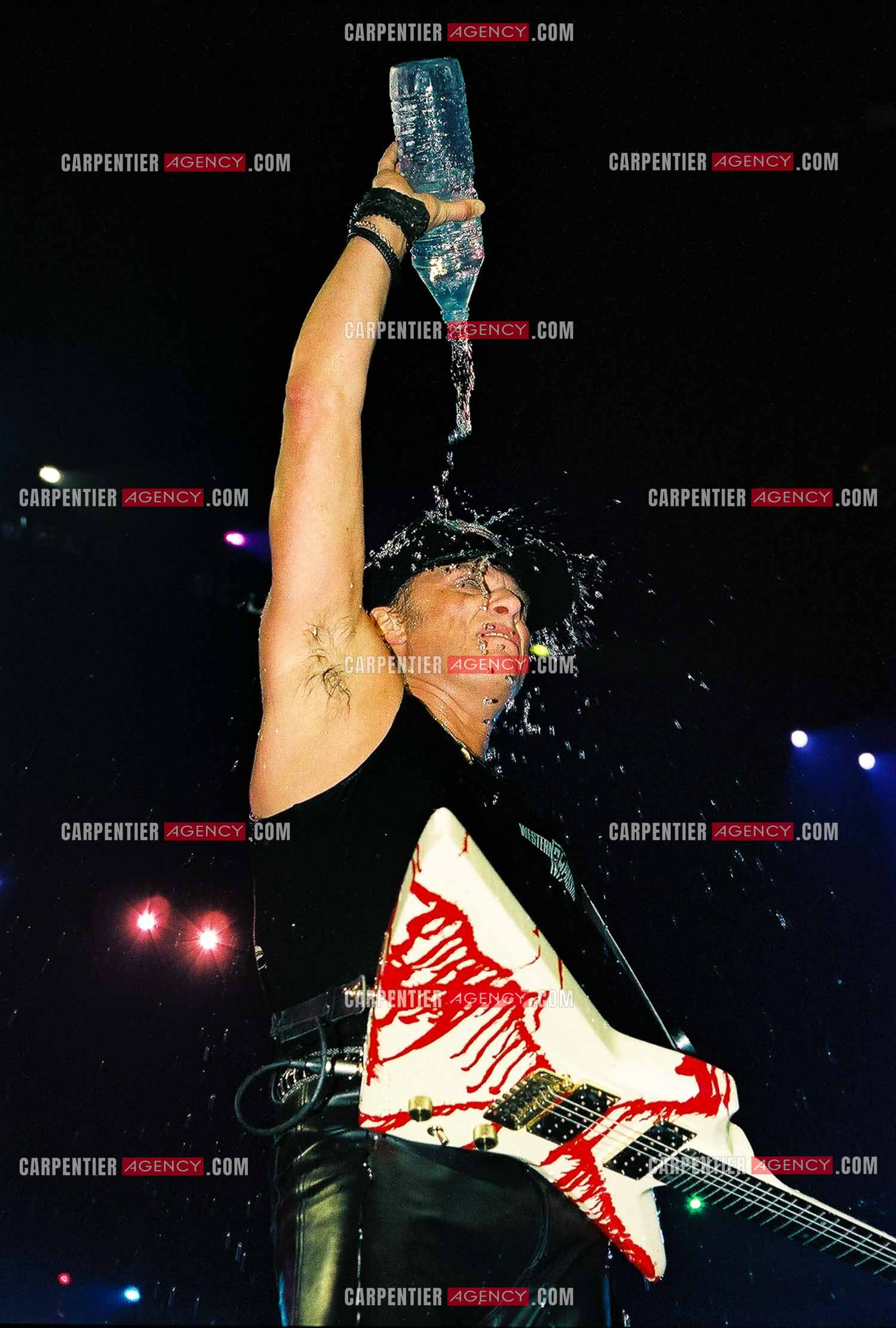 Le chanteur Johnny Hallyday en concert au Palais omnisports de Paris-Bercy du 14 septembre au 4 octobre 1992. Johnny chauffe son public au maximum et n'hésite pas à s'arroser avec sa bouteille d'eau.       ( Exclusif )