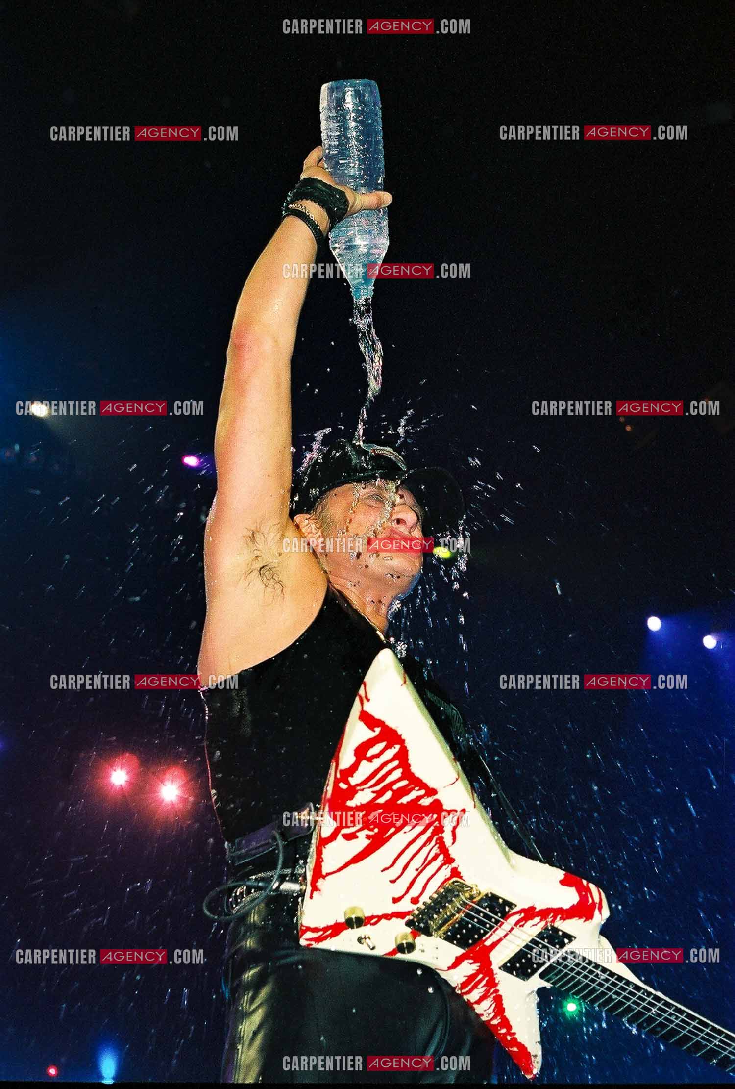 Le chanteur Johnny Hallyday en concert au Palais omnisports de Paris-Bercy du 14 septembre au 4 octobre 1992. Johnny chauffe son public au maximum et n'hésite pas à s'arroser avec sa bouteille d'eau.       ( Exclusif )