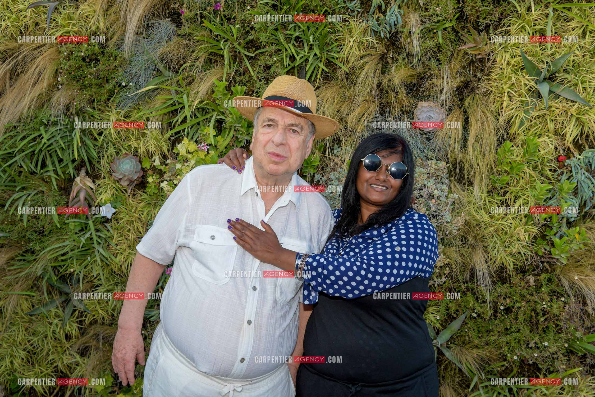 Paul-Loup Sulitzer lors d'une ballade sur le port de St Tropez. Ici en terrasse du bar de plage le " TAHAITI “  avec sa compagne  Supriya Answya Devi Rathoar.  ( Exclusif )