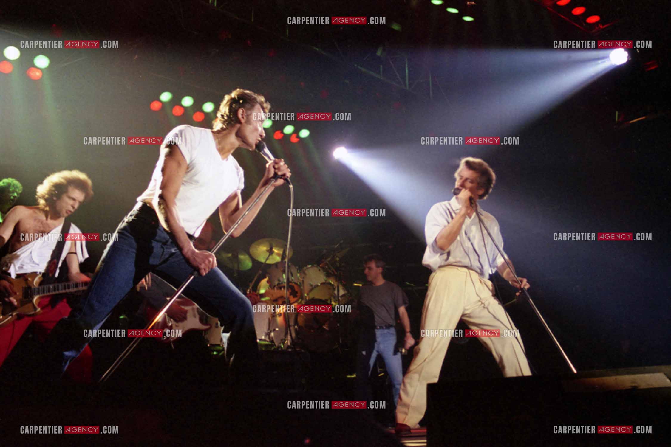 Le chanteur Johnny Hallyday et son ami Eddy Mitchell en concert au Zénith de Paris.