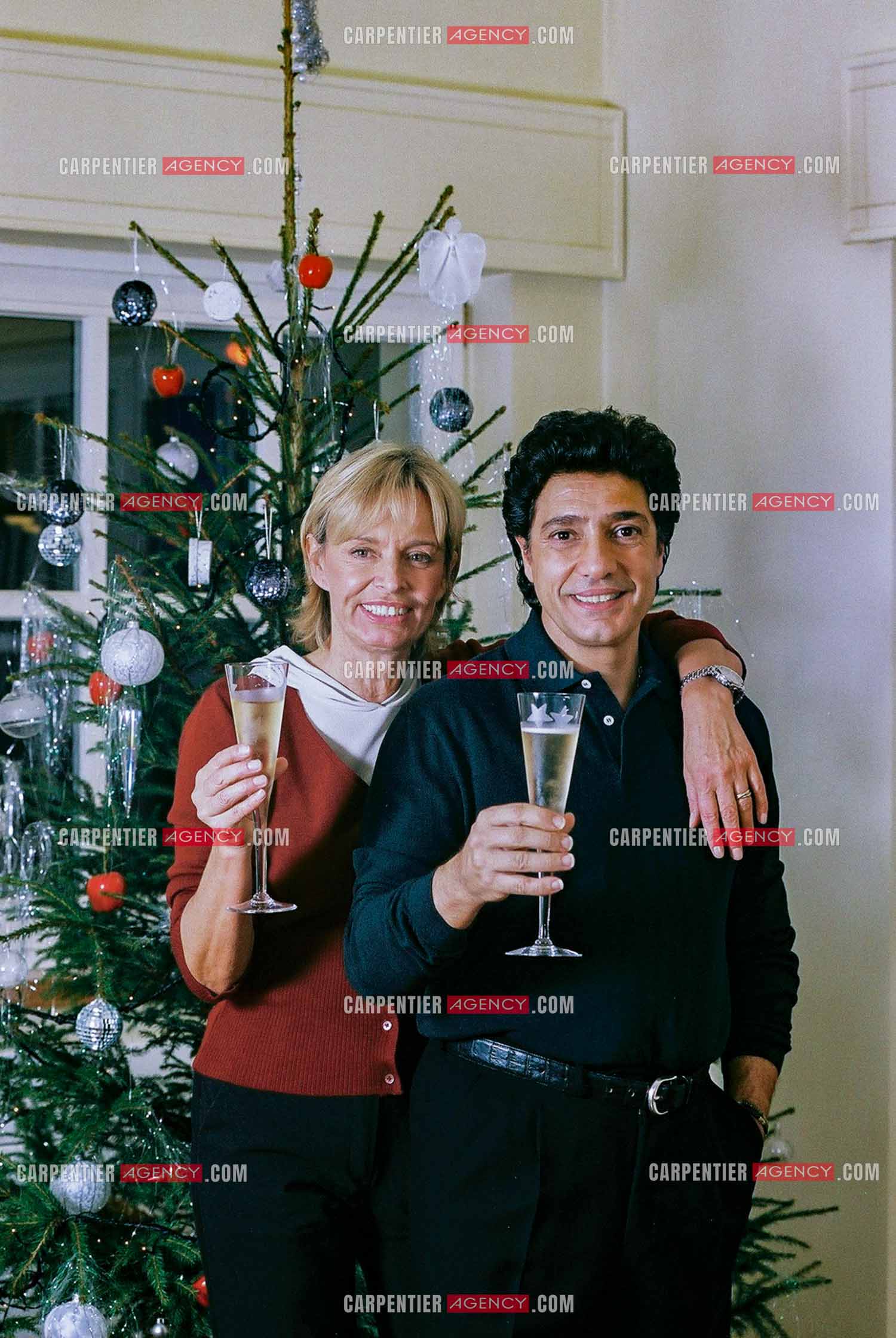 Le chanteur Frédéric François chez lui en Belgique se prépare à fêter Noël en famille autour du sapin. Frédéric et sa femme Monique trinquent pour annoncer les fêtes.  ( Exclusif )