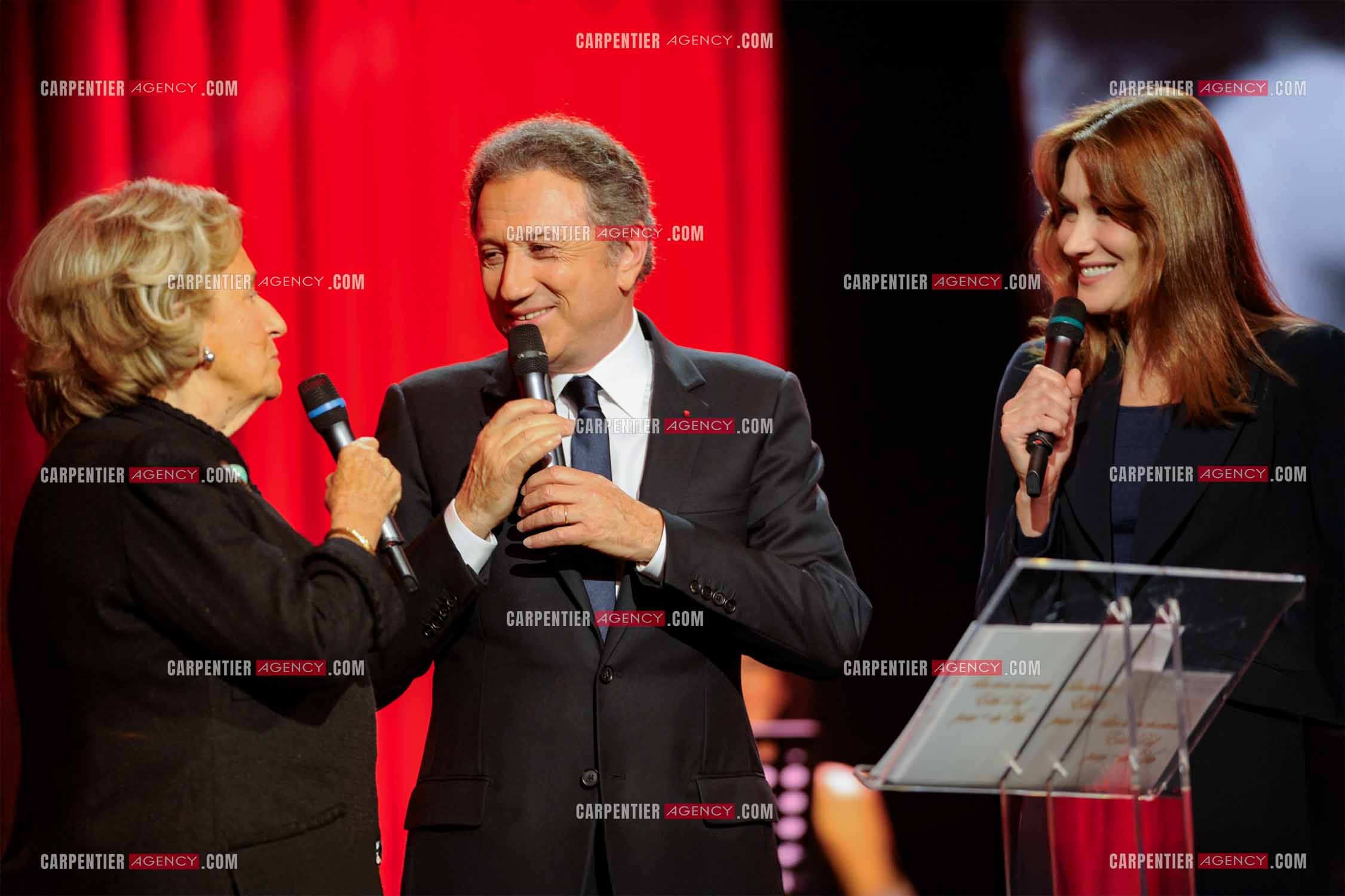 Michel Drucker entre les deux premières dames, Bernadette Chirac et Carla Bruni Sarkosy pour l'émission spéciale sur Edith Piaf “Pour + de Vie“.